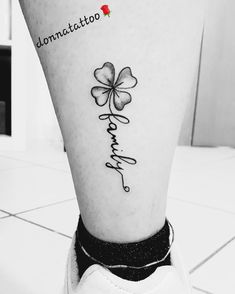 a black and white photo of a person's foot with a clover tattoo on it