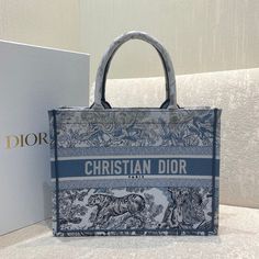 Description   CHRSTN DR Medium DYOR Book Tote Blue Toile de Jouy Reverse Embroidery, Blue, For Women Women’s Handbags, Shoulder Bags, 36cm CD M1296ZRGO_M928  Rep 1:1  Size: 36 x 27.5 x 16.5 cm (Length x Width x Height)   Introduced by Maria Grazia Chiuri, Creative Director of CHRSTN DR, the DYOR Book Tote has become a staple of the DYOR aesthetic. Designed to hold all the daily essentials, the style is fully embroidered with a blue Toile de Jouy Reverse motif, a variation of the House’s hallmark pattern with a play on reversed colors. Adorned with the ‘CHRSTN DR PARIS’ signature on the front, the medium tote exemplifies the House’s signature savoir-faire and may be carried by hand or worn over the shoulder.   ‘CHRSTN DR PARIS’ signature on the front   Includes dust bag.  This product is of Christian Dior Handbags, Dior Aesthetic, Embroidery Blue, Dior Book, Louis Vuitton Shirt, Chanel Shirt, Blue Toile, Dior Book Tote, Maria Grazia Chiuri