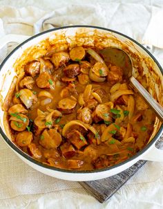 a pot filled with meat and mushrooms covered in gravy