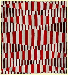 a red, white and black quilt with squares on the bottom in different shades of red