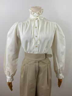 This blouse is essencial pieces for your wardrobe In perfect condition, from 74s. 32" to 36" bust  14" shoulder to shoulder  20" pit arm Fitted Blouse With Smocked Cuffs And Ruffled Collar, Fitted Blouse With Smocked Cuffs And Bishop Sleeves, Vintage Fitted Tops With Gathered Sleeves, Classic Fitted Blouse With Gathered Sleeves, Vintage Lantern Sleeve Tops For Daywear, Vintage Bishop Sleeve Formal Blouse, Vintage Fitted Blouse With Gathered Sleeves, Vintage Bishop Sleeve Blouse For Formal Occasions, Vintage Beige Puff Sleeve Blouse