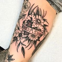 a woman's arm with tattoos and flowers on it