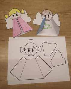 paper cut out of the shape of an angel and another piece of paper with scissors