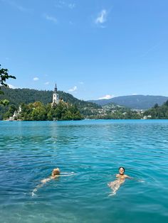 two people are swimming in the lake