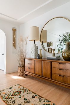 a living room filled with furniture and a large mirror on top of a wooden dresser