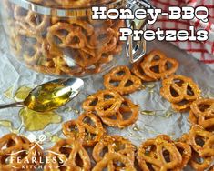 honey - bbq pretzels are sitting on a table next to a jar and spoon