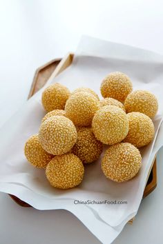 a bowl filled with sesame balls on top of a counter next to a knife and fork