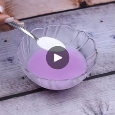 a person is spooning something out of a glass bowl with purple liquid in it