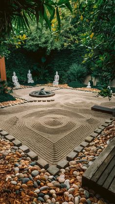 a sand garden with buddha statues in the middle and rocks on the ground around it