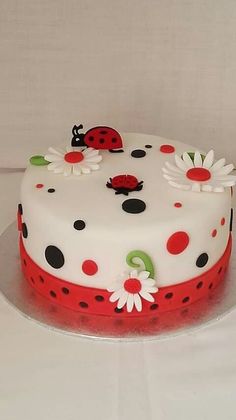 a cake decorated with ladybugs and daisies