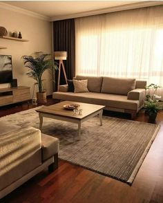 a living room filled with furniture and a flat screen tv on top of a wooden table