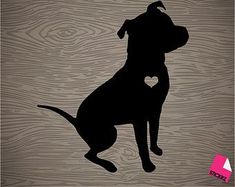 a black dog with a heart on it's back sitting in front of a wooden background