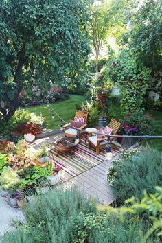 an outdoor deck with chairs and plants surrounding it