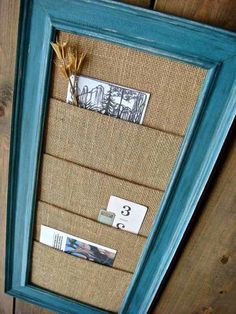 a blue frame with some pictures hanging on it and two tags attached to the front