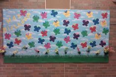 a bulletin board with flowers on it in front of a brick wall