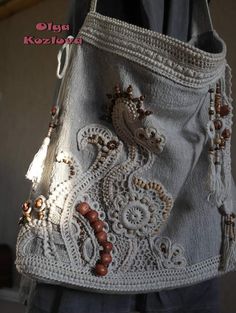 a white purse with beaded details on the front and side, hanging from a hook