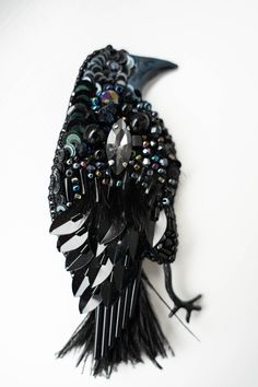 a black bird brooch sitting on top of a white table