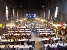 a large room filled with lots of tables covered in white tablecloths