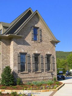 a large brick house with two windows on the front and side of it's roof