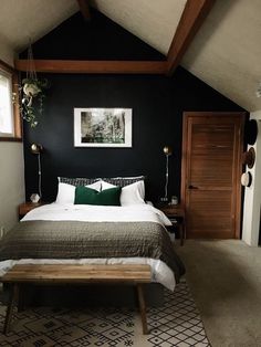 a bedroom with black walls and white bedding