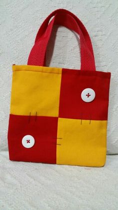 a red and yellow bag sitting on top of a bed