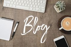 the word blog written in white on a wooden table next to a cup of coffee