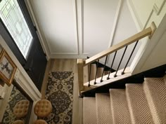 an overhead view of a stair case in a house with carpet and rugs on the floor