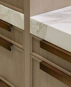 a kitchen counter with marble top and wooden drawers