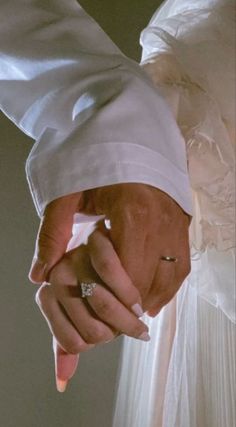 the bride and groom hold hands as they stand close together