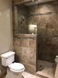 a bathroom with a walk in shower next to a toilet