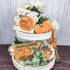 three tiered display with pumpkins and flowers