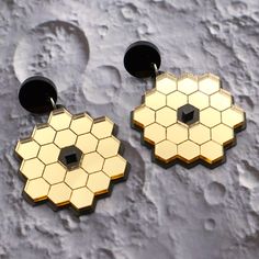 The James Webb Space Telescope has been delivering stunning imagery of the universe with it's high resolution, highly sensitive equipment. An array of 18 primary mirrors and a secondary mirror focuses the light from the cosmos onto the telescope in the centre. These JWST earrings depict the telescope and primary mirror array, backed onto a black backing plate, all laser cut and assembled in black acrylic, gold mirror acrylic and a thin black plastic respectively. The main component measures 4cm Science Earrings, Gold Mirror Acrylic, Recycled Earrings, Recycled Necklaces, James Webb, James Webb Space Telescope, Science Lover, Mirror Acrylic, Space Telescope