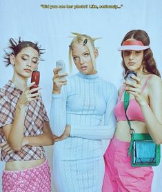 three women standing next to each other with cell phones in their hands and one holding a purse