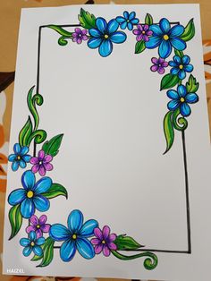 a drawing of blue and purple flowers with green leaves in the center on white paper