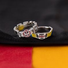 two rings with flags on them sitting on top of a black cloth next to each other