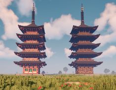 two tall pagodas in the middle of a field