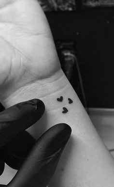 a woman's arm with small hearts on it