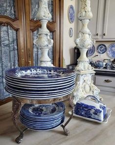 blue and white plates stacked on top of each other in front of an ornate cabinet