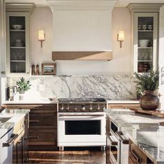 a white stove top oven sitting inside of a kitchen next to wooden cabinets and counter tops