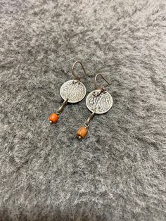 This is an old silver berber earrings from morocco with old silver coins. It is made out of Silver coins that date back to 1881 (1299 Hijri calendar), and one small coral beads . These earrings have a good size and weight to be worn. They are a exceptional and unique piece of jewelry. Coin Diameter : 1.7cm Length (including hooks) : 5cm Weight (Pair) : 6,6g Silver Bohemian Earrings With Round Beads, Silver Bead Artisan Earrings, Artisan Silver Earrings With Silver Beads, Traditional Silver Beaded Round Earrings, Traditional Silver Round Bead Earrings, Traditional Silver Round Beaded Earrings, Traditional Round Silver Beaded Earrings, Traditional Silver Nickel-free Beaded Earrings, Traditional Silver Beaded Earrings With Round Beads