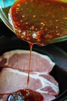 the sauce is being poured on top of raw meat in the slow cooker to be cooked