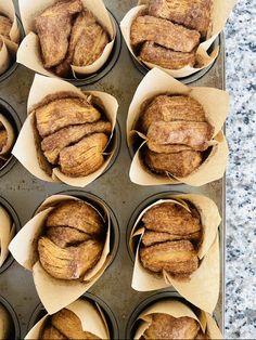 several muffins are in paper cups on a baking tray, ready to be baked