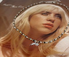 a woman with blonde hair wearing a beaded choker and necklace on her neck