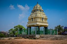 a tall white tower sitting on top of a dirt field