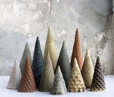 five different colored cones are lined up on the table next to each other in front of a concrete wall