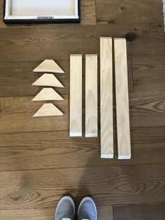 some pieces of wood sitting on top of a wooden floor next to a pair of shoes