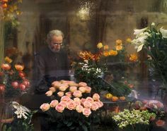 a man looking at flowers through a window