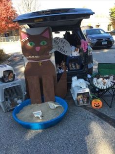 a cat statue sitting in the back of a car next to a pile of litter