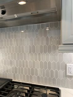 a stove top oven sitting inside of a kitchen next to a wall mounted range hood