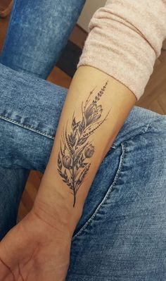 a woman's arm with a flower tattoo on the left side of her wrist